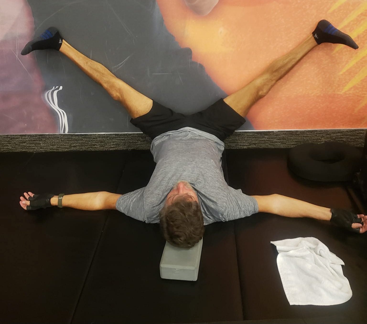 John Kilgore lying on his back with legs opened wide against a wall