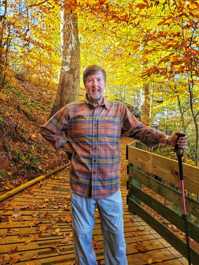 John Kilgore hiking among autumn trees